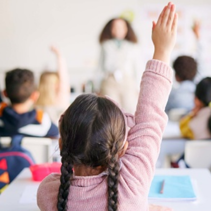 Students in classroom, some with raised hands