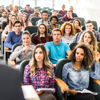 Students studying together, looking at device