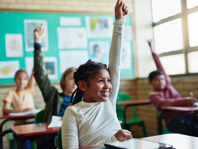 Child raising hand in classroom