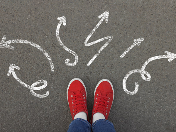 Red shoes standing near arrows pointing in many directions.