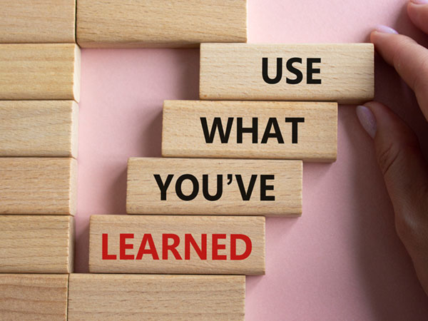 Wooden blocks spelling "USE WHAT YOU'VE LEARNED" with "LEARNED" in red