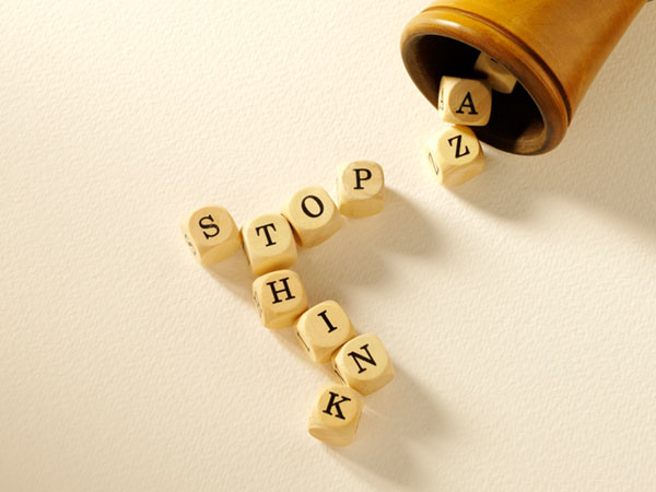 Letter cubes spelling 'STOP' and 'THINK' on a surface