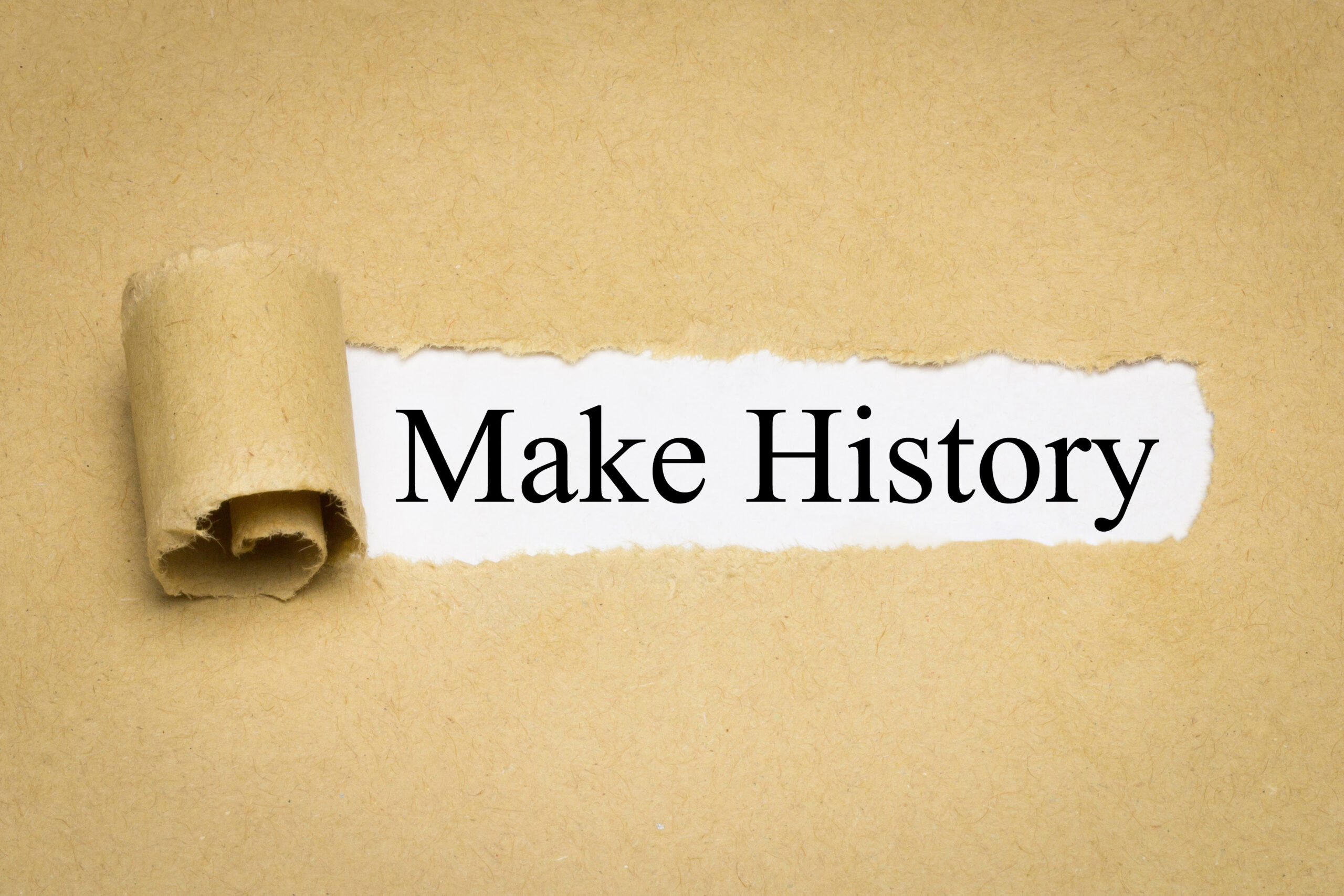 Text "Make History" on torn paper against beige background.