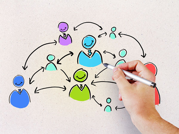 Hand drawing a network of interconnected people with arrows.
