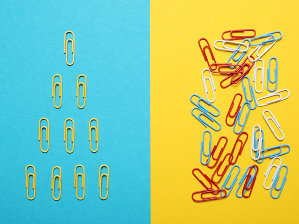 Paperclips arranged neatly on blue side, scattered on yellow side.