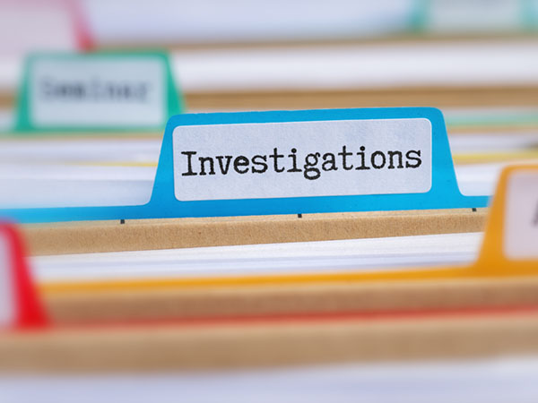 File folder labeled "Investigations" among other colored file dividers.