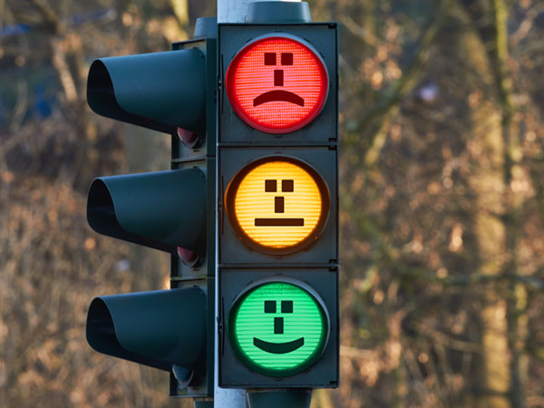 Traffic light with emoji faces on each signal.