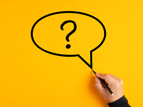 Hand drawing question mark in speech bubble on yellow background.