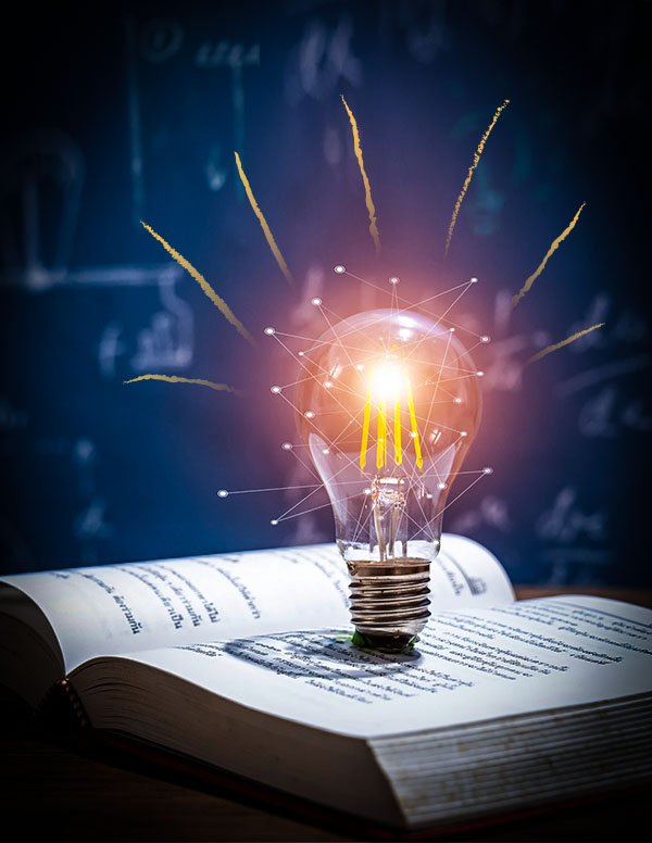 Glowing light bulb on open book symbolizing ideas, learning, and inspiration.