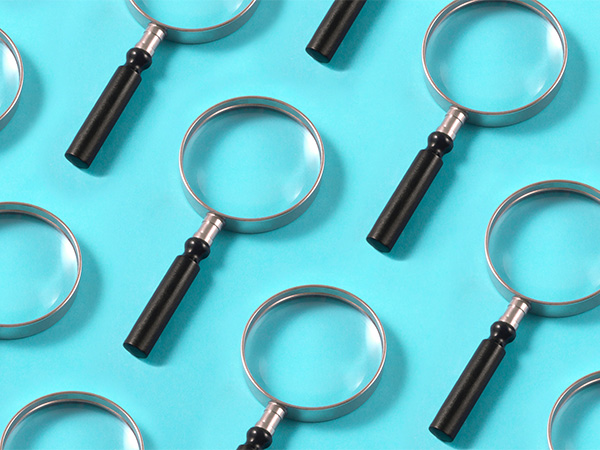 Multiple magnifying glasses arranged on light blue background.