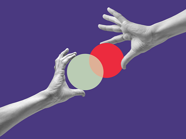 Two hands reaching for overlapping colorful circles on purple background.