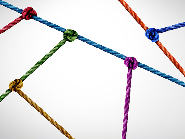 Colorful knotted ropes intersecting on white background.