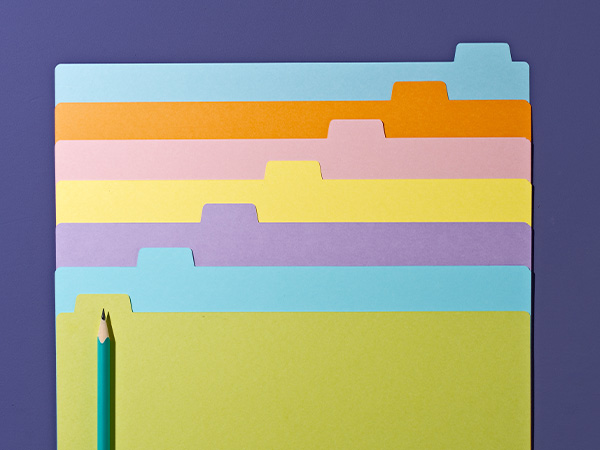 Colorful file folders stacked with green pencil, on purple background.