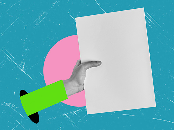 Hand in green sleeve holding blank white paper against teal background.