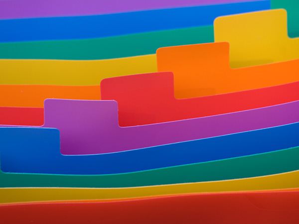 Colorful curved layers of folder with tabs in an abstract rainbow pattern.