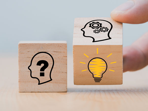 Two wooden blocks showing question mark and lightbulb ideas.
