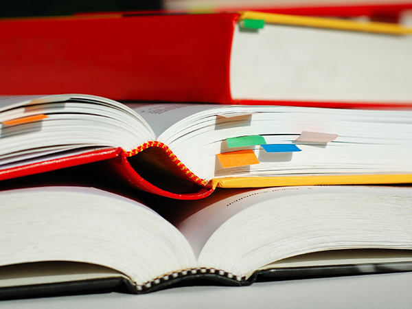 Open books with colorful sticky notes marking various pages.