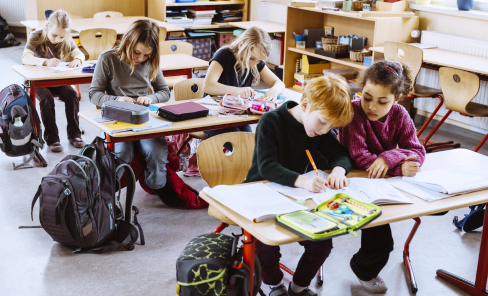 Students working at desks in a classroom.